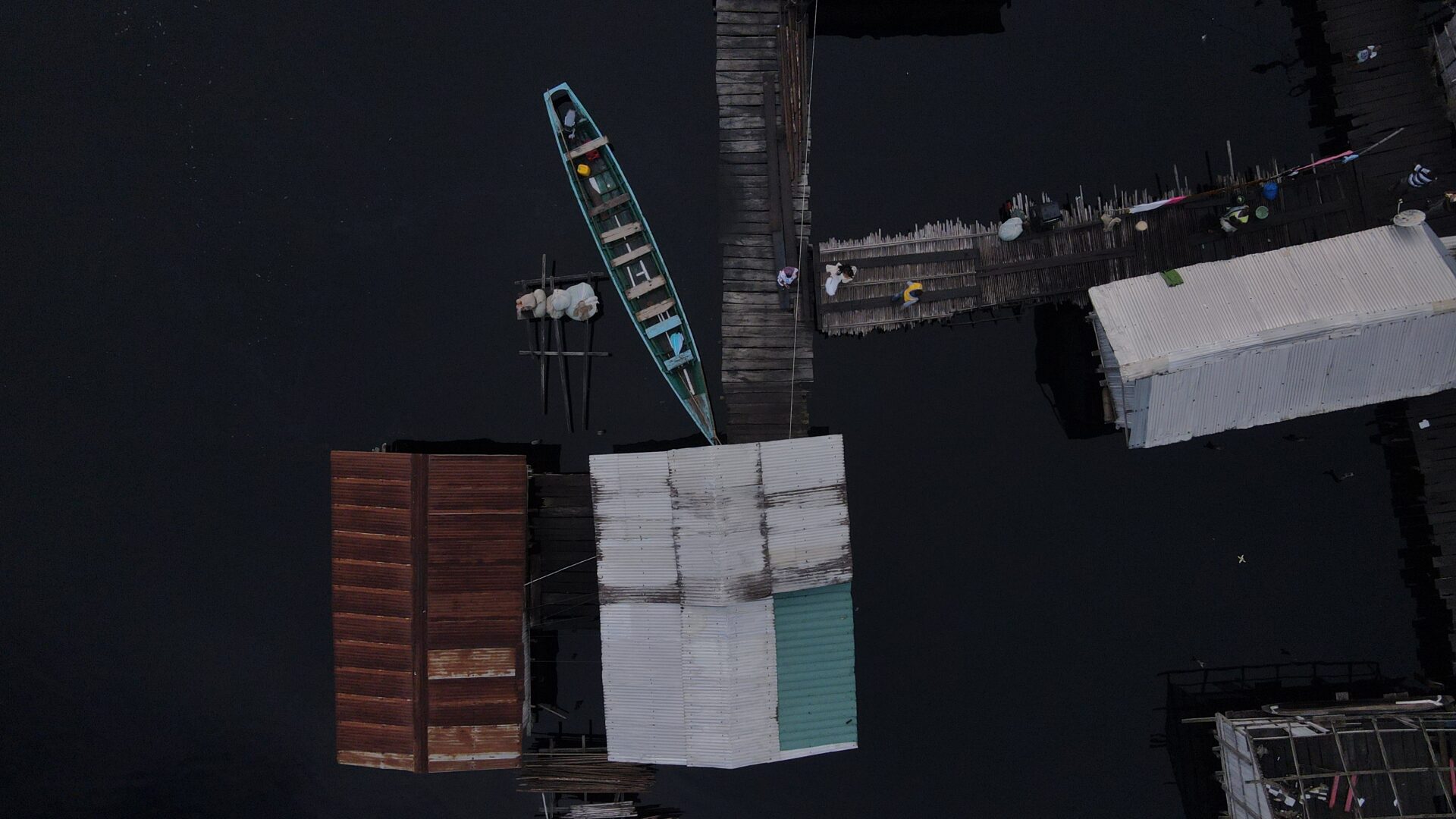 Boat on dark water next to piers