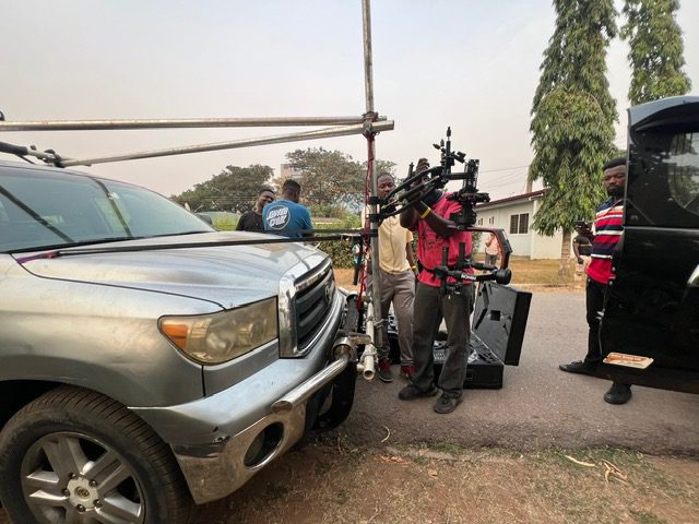 Team adjusts equipment on parked car