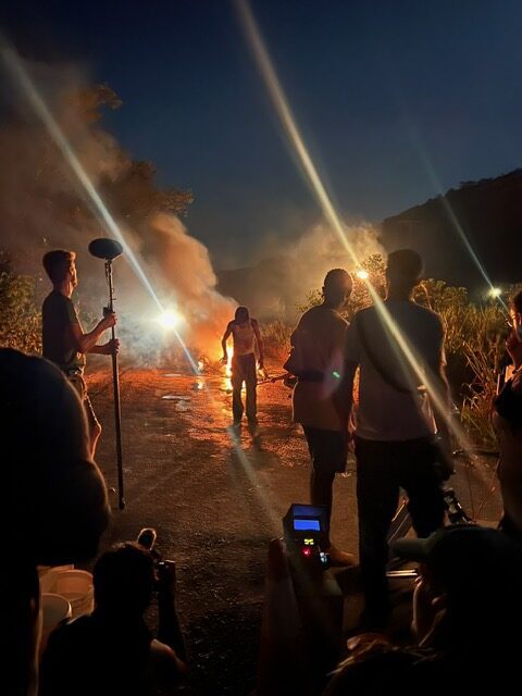 Crew filming near fire at night